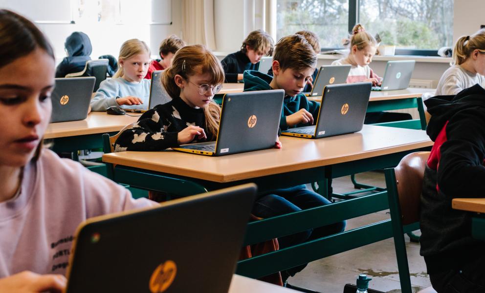 Kinderen in de klas aan de slag op laptops
