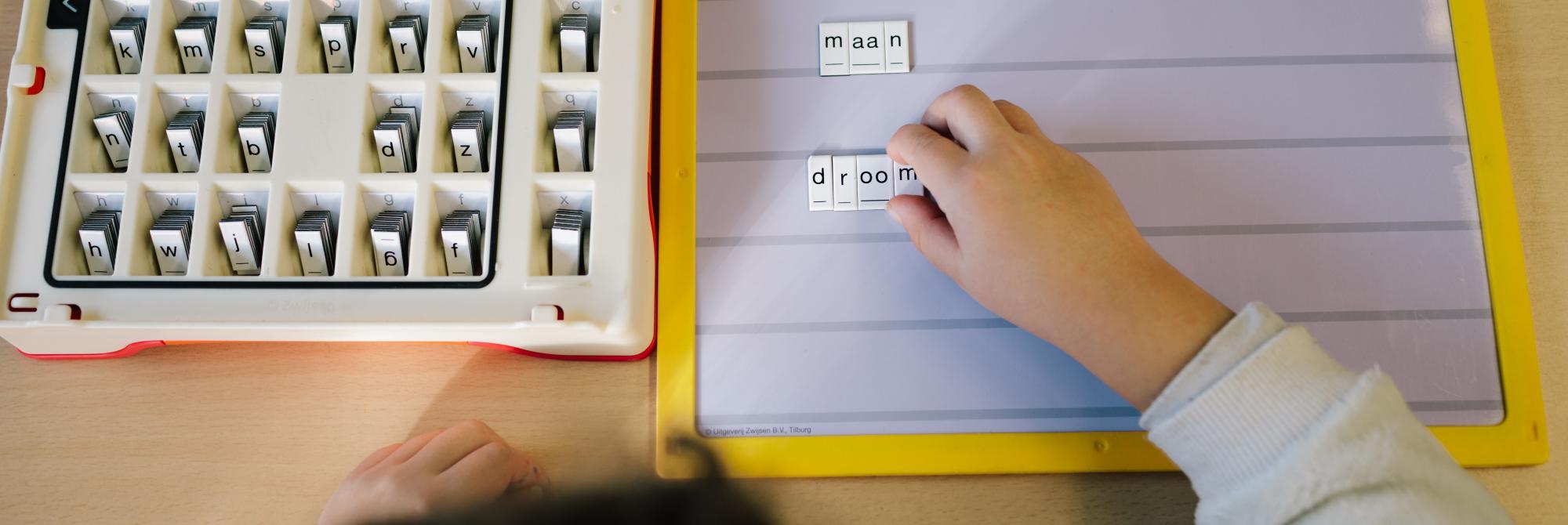Kind legt letters op magneetbordje