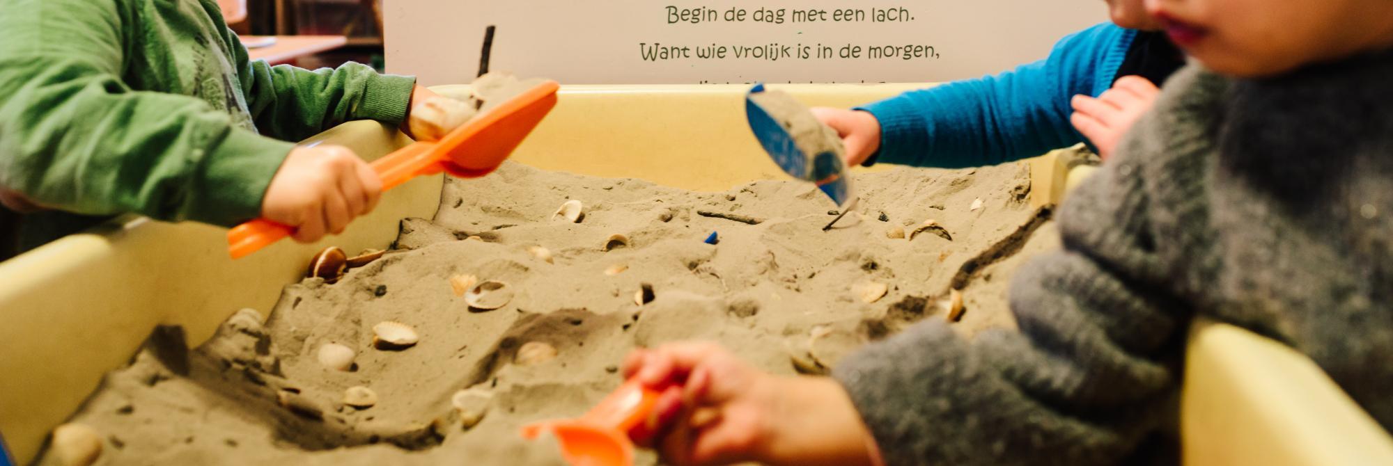 Kinderen spelen samen in zandbak in de klas